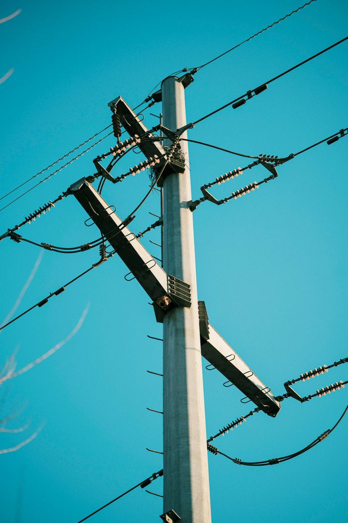 The Art of Drawing Readers In: Your attractive post title goes here A tall electricity transmission tower with cables against a bright blue sky, showcasing industrial infrastructure.